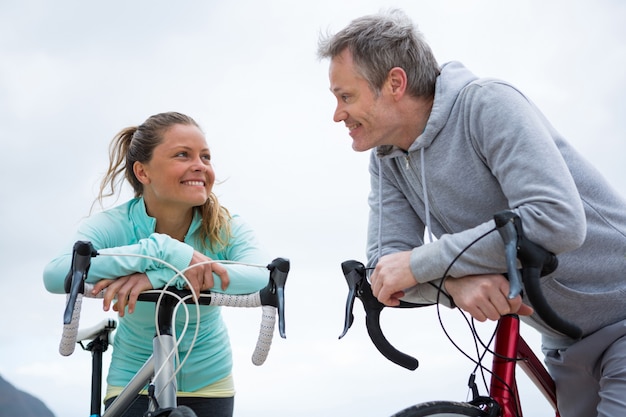 Couple s'appuyant sur le vélo tout en interagissant les uns avec les autres