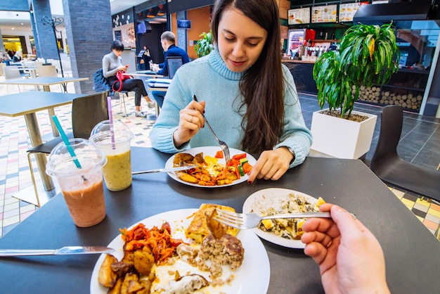 Un couple s'assoit dans un café du centre commercial et dîne au café