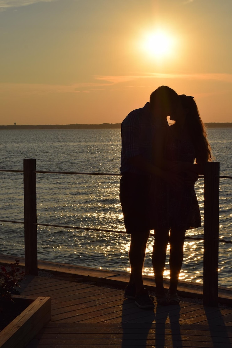 Photo un couple s'embrasse au coucher du soleil