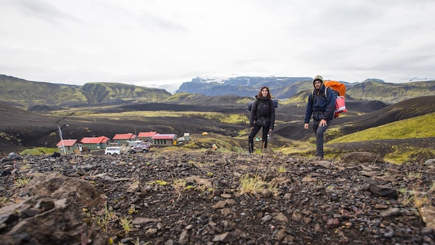 Un couple avec des sacs à dos quittant l'abri du trek de 54 km de Landmannalaugar Islande