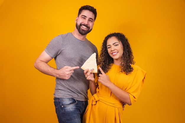 Couple Saint Valentin mangeant du fromage sur fond jaune