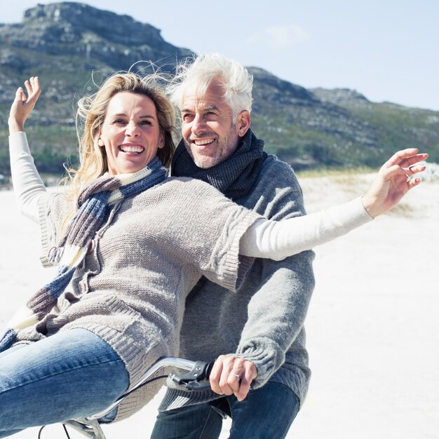 Couple sans soucis va faire du vélo sur la plage