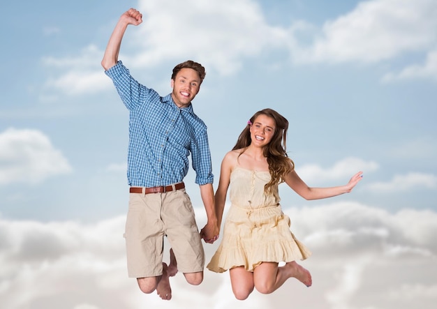 Couple sautant dans l'air contre ciel flou