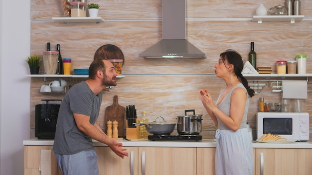 Un couple se crie dessus dans la cuisine le matin. Les jeunes couples se querellent dans la cuisine. L'homme et la femme crient de frustration lors d'une conversation à domicile.