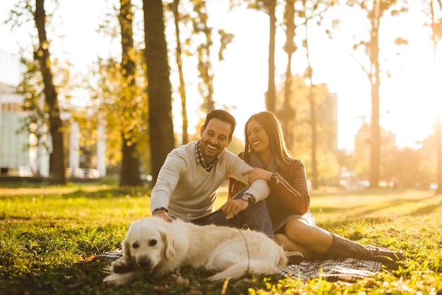 Couple se détendre avec leur chien dans le parc