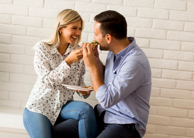 Couple se détendre à la maison et manger une pizza de bon goût