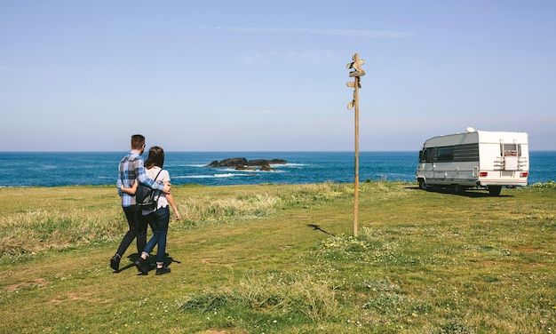 Couple se promenant près de la côte avec un camping-car