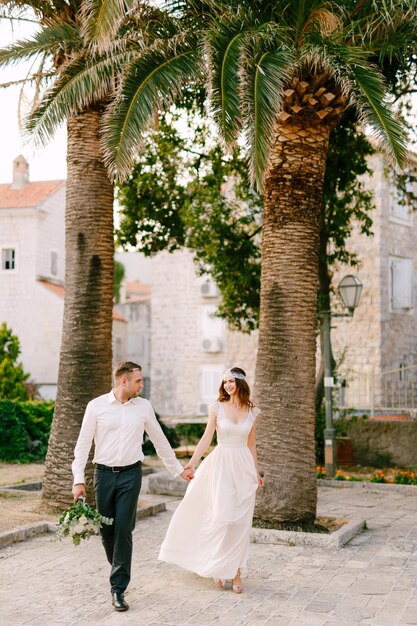 Un couple se promène devant des palmiers