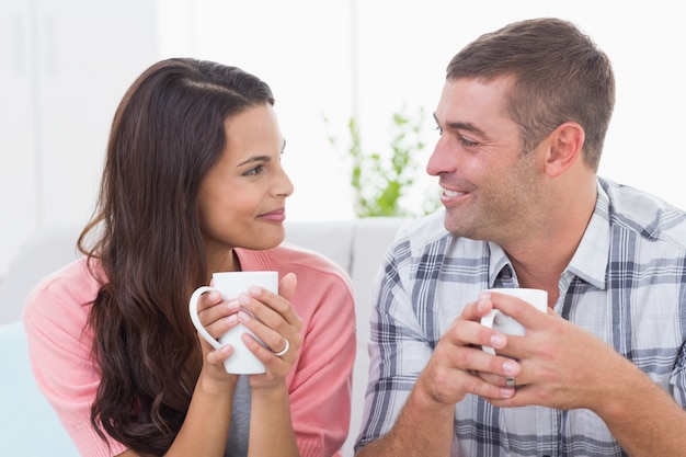 Couple se regardant en prenant un café