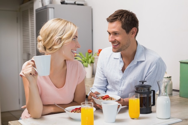 Couple se regardant en prenant son petit déjeuner à la maison