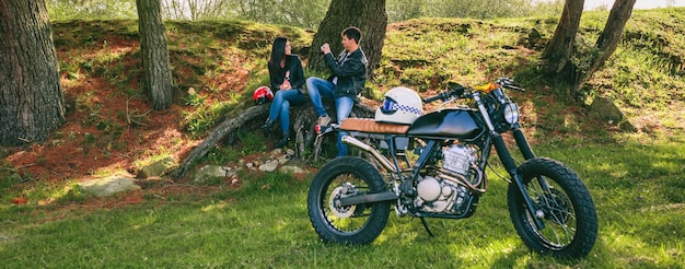 Photo couple se reposant d'un voyage en moto prenant une photo