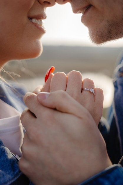 Un couple se tenant la main, l'un d'eux porte une bague.