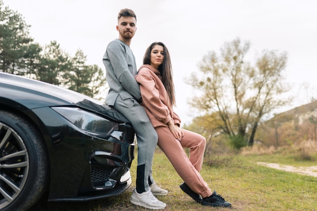 Couple se tient près de la voiture