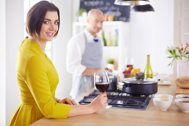 Un couple séduisant amoureux de la cuisine et ouvre le vin dans la cuisine pendant qu'ils préparent le dîner pour une soirée romantique