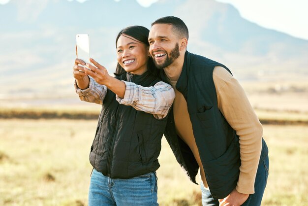 Couple selfie et voyage à la campagne en plein air et heureux avec le téléphone pour la photographie en vacances dans l'arrière-pays australien Mémoire sourire en photo et smartphone aventure et bonheur avec la liberté