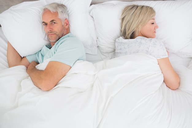 Couple senior couché dans son lit à la maison