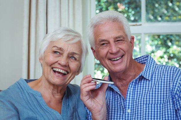 Couple Senior à l'écoute de la musique par téléphone