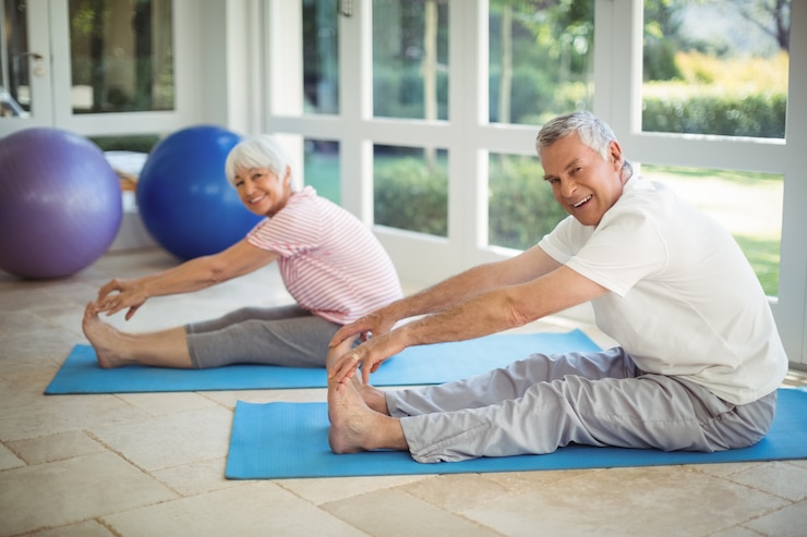 Photo couple senior exercice d'étirement sur tapis d'exercice