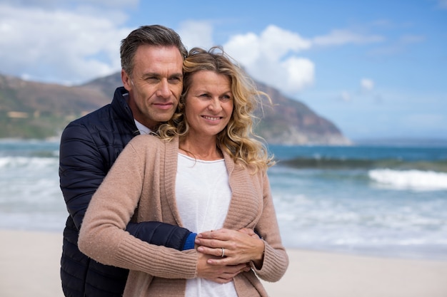 Couple senior s'embrassant sur la plage