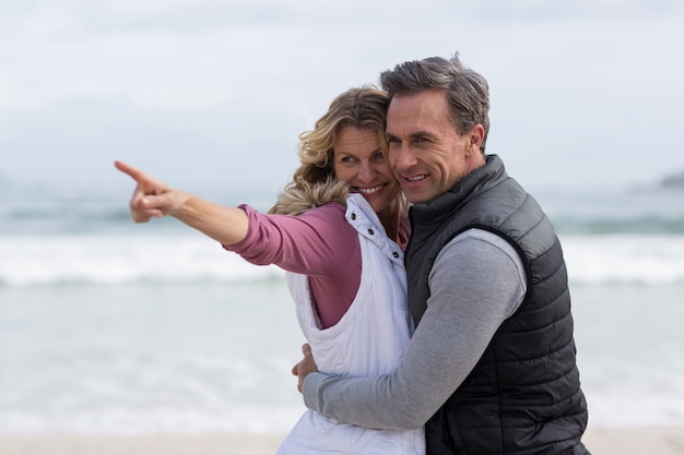 Couple senior s'embrassant sur la plage