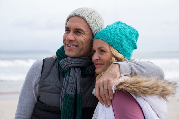 Photo couple senior s'embrassant sur la plage