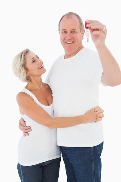 Couple senior souriant à la caméra avec la nouvelle clé de la maison