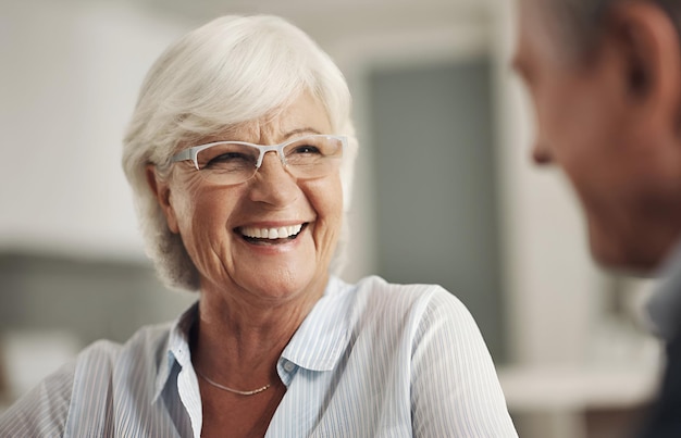 Un couple de seniors drôle et une conversation à la maison se liant et s'amusant