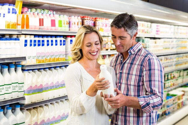 Couple souriant, acheter du lait