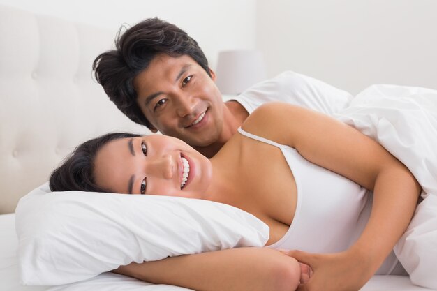 Couple souriant au lit