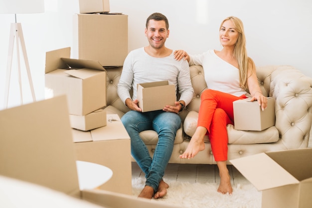 Photo couple souriant avec des boîtes en carton