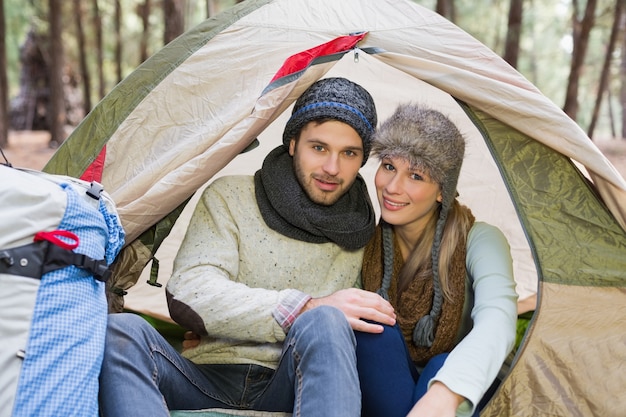 Couple souriant dans la tente avec sac à dos dans le désert