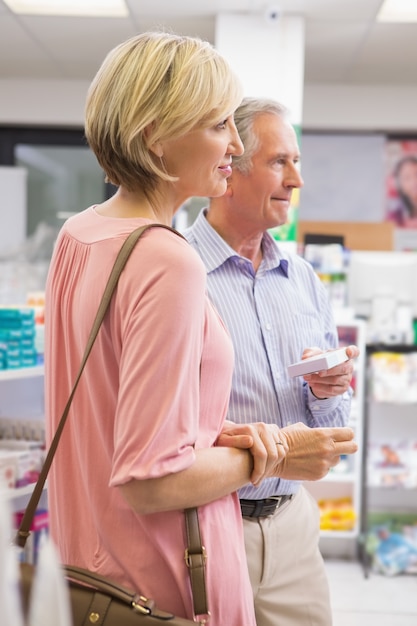 Couple souriant debout avec des médicaments