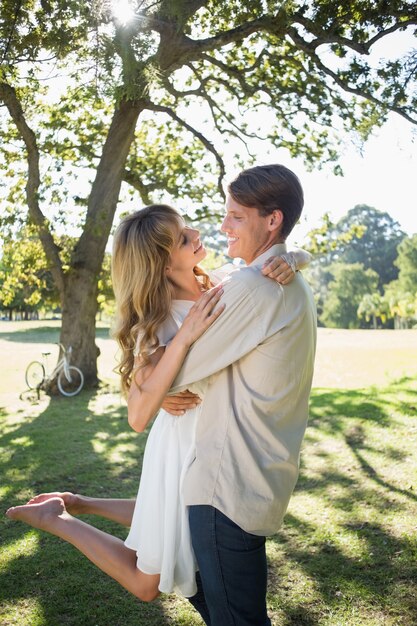 Couple souriant embrassant dans le parc