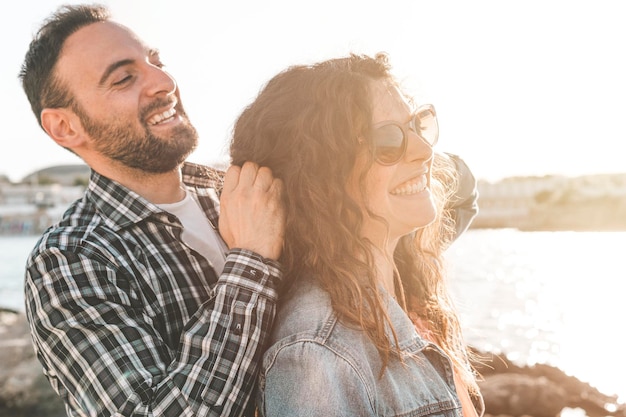 Un couple souriant à l'extérieur au coucher du soleil