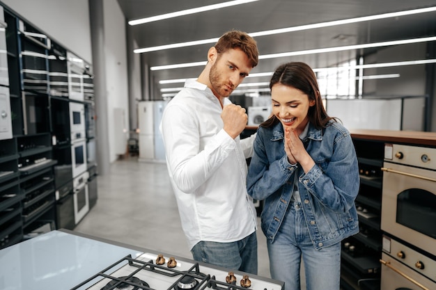 Un couple souriant heureux vient d'acheter de nouveaux appareils électroménagers dans un hypermarché