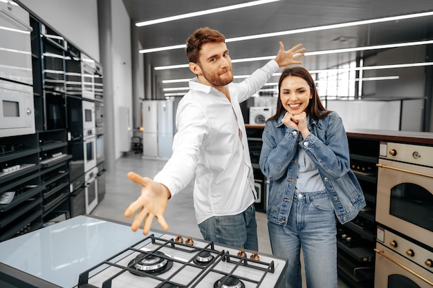 Un couple souriant heureux vient d'acheter de nouveaux appareils électroménagers dans un hypermarché