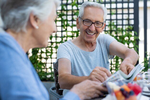 Couple souriant, lisant le journal