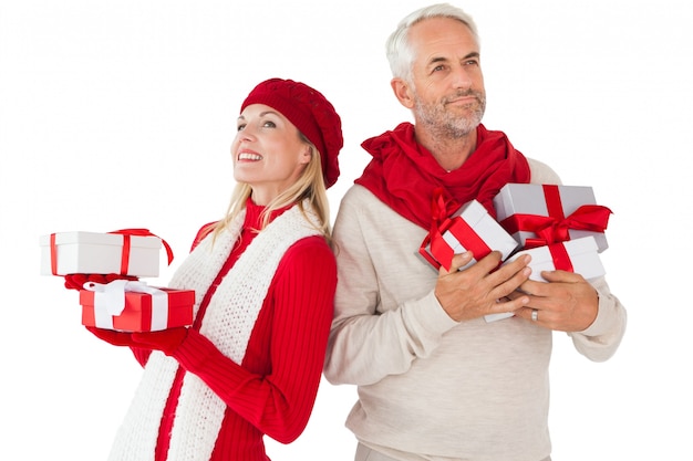 Couple souriant en mode hiver tenant des cadeaux