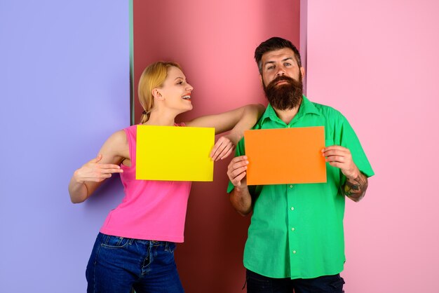 Un couple souriant avec des panneaux vides présentant un babillard un couple tient des panneaux publicitaires heureux