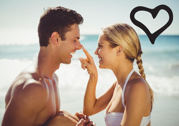 Couple souriant sur la plage avec coeur noir