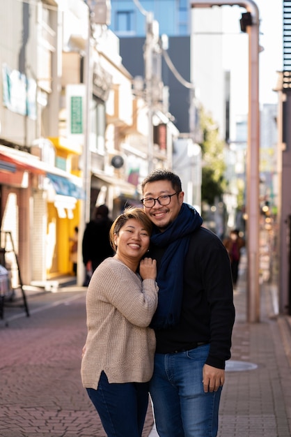 Photo couple souriant à plan moyen en ville