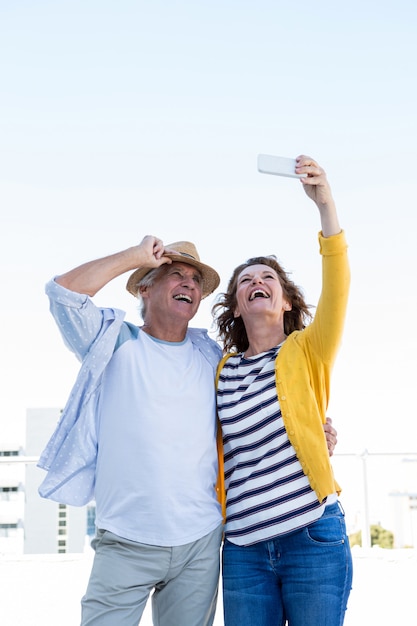 Couple souriant prenant selfie