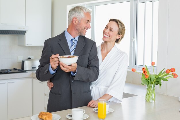 Couple souriant, prenant son petit déjeuner le matin avant le travail