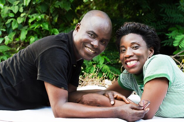 Photo ce couple souriant qui regarde la caméra.