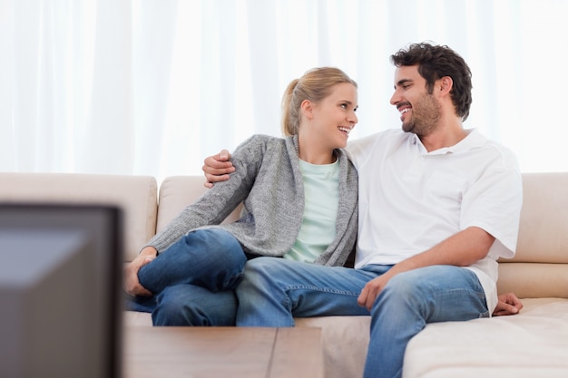 Couple souriant en regardant la télévision