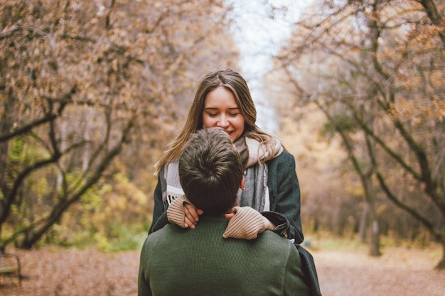Un couple souriant s'embrassant contre les arbres