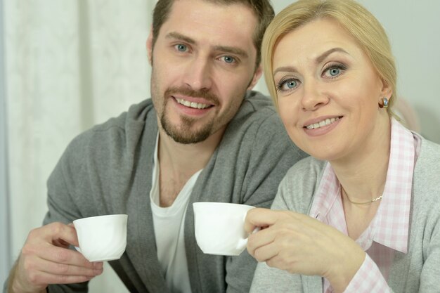 couple souriant à table avec café et nourriture