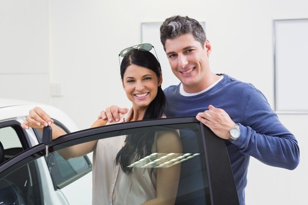 Couple souriant tenant leur nouvelle clé de voiture