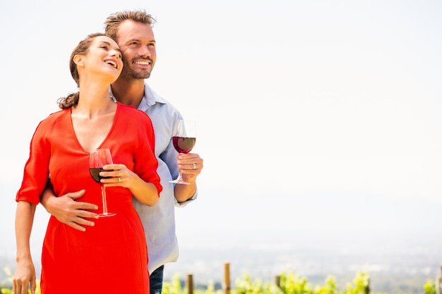 Couple souriant avec vin rouge à la recherche de suite