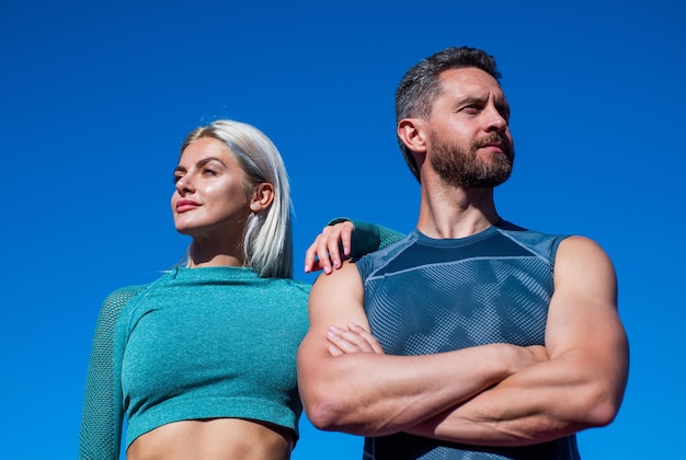 Couple de sport confiant en vêtements de sport se détendre sur fond de ciel fitness